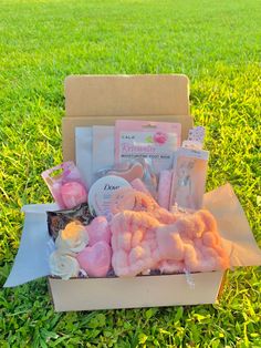 a box filled with lots of pink stuff on top of green grass next to a field