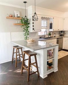 a kitchen with two stools and an island