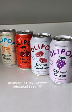 six cans of soda are lined up on a counter top, with the words ollipop written below them