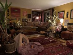 a living room filled with lots of furniture and christmas lights on the wall behind it