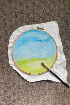 a painting on a piece of paper with a brush next to it