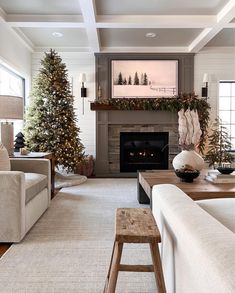 a living room filled with furniture and a fire place covered in christmas tree decorating