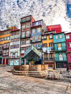 the colorful buildings are lined up against the blue and white sky with clouds in the background