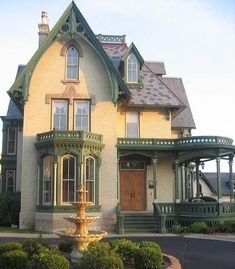 a large house with a fountain in front of it