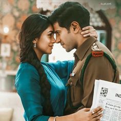 a man and woman embracing each other in front of a newspaper