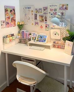 a white desk topped with a computer and lots of pictures on the wall behind it