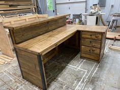 an office desk made out of wood in a shop with lots of other work tools