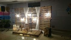 an empty room with some lights on the wall and wooden pallets in front of it