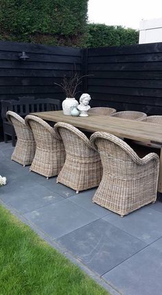 an outdoor dining table with wicker chairs