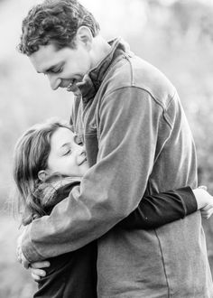 a man and woman embracing each other in black and white