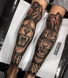 a man's legs with tattoos on them and two tigers in the middle of his leg