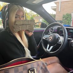 a woman sitting in the driver's seat of a car