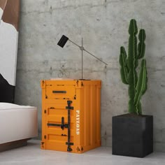 an orange box sitting next to a cactus and a lamp on top of a table