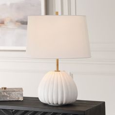 a white lamp sitting on top of a wooden table