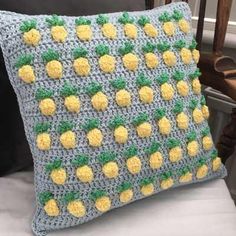 a crocheted pillow with pineapples on it