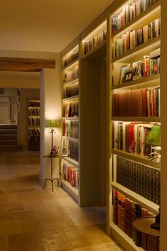 an empty library with many books on the shelves and lamps in front of each bookcase