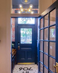 an entry way with a blue door and patterned tile floor in front of the doorway