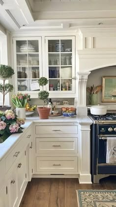 a kitchen with an oven, stove and counter tops in white cabinetry next to a wooden floor