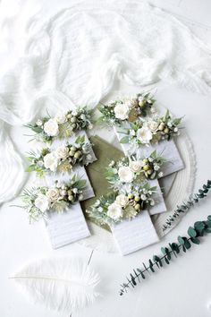 white flowers and greenery are arranged in the shape of a heart