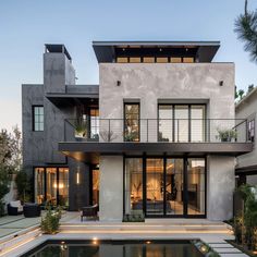 a house with a pool in front of it and lots of windows on the side