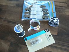 the contents of a crafting kit are laid out on a wooden table with tape, scissors and other items