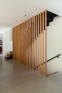 an empty room with wood slats on the wall and stairs leading up to it