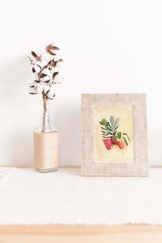 a small potted plant sitting on top of a table next to a framed photo