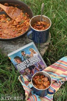 some food is sitting on the ground next to an open book and a cup of soup