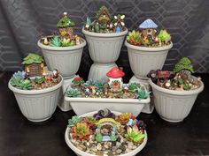 there are many potted plants in the shape of gnome's houses on display