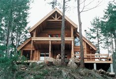 a log cabin sits on top of a hill surrounded by trees and rocks in the woods