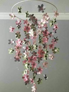 a chandelier with pink and green flowers hanging from it's sides in a room