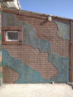 a brick wall with blue and green paint on it