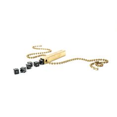 a gold chain with dices on it and two black ones next to each other