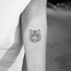 a black and white photo of a tiger tattoo on the arm