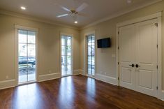 an empty living room with hard wood floors and sliding glass doors that lead to the patio