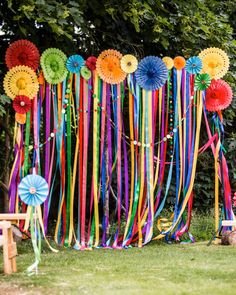 there are many colorful streamers hanging on the wall with ribbons attached to each one