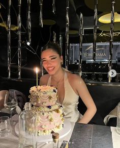 a woman sitting at a table with a cake in front of her