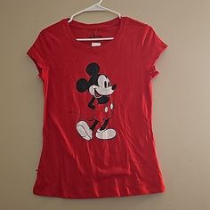 a red t - shirt with a mickey mouse design on the front and back, hanging from a hanger