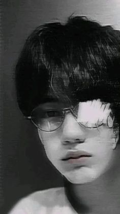 a young man wearing glasses with the reflection of his face in it's mirror