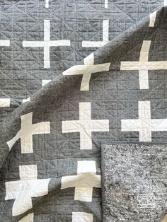 a gray and white quilt on top of a bed