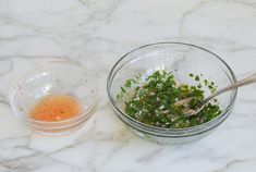 a glass bowl filled with chopped herbs next to a plastic container full of seasoning