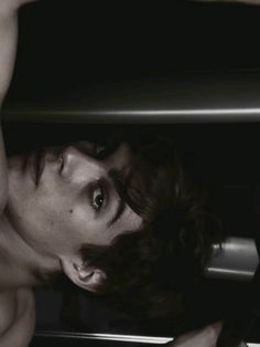 a shirtless man leaning over an oven door