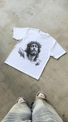 Elevate your wardrobe with this Men's Christian Shirt, a perfect blend of timeless faith and trendy design. Featuring a bold Jesus-inspired graphic, this oversized shirt channels Y2K streetwear vibes while keeping the focus on your beliefs. Whether you're heading to church, a casual outing, or a youth event, this shirt makes a strong statement in both style and faith. Designed for comfort and versatility, this unisex Christian shirt is perfect for layering or wearing on its own. Its oversized fi Jesus Street Wear, Jesus Loves You Shirt, Mens Graphic Tees Prints, 2000 Streetwear, Clothing Brand Inspiration, Jesus Graphic, Jesus Clothes, Apparel Design Inspiration, Christian Streetwear