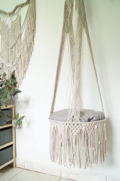 a hammock hanging from the wall next to a potted plant