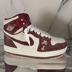 a pair of red and white sneakers sitting on top of a marble floor