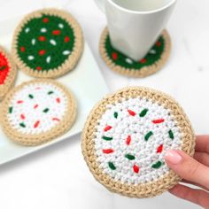 crocheted coasters are being displayed on a plate with a coffee cup and saucer