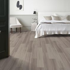 a bedroom with white walls and wood flooring on the floors is pictured in this image