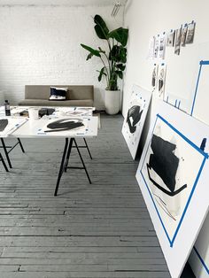 a living room filled with furniture and pictures on the wall next to a whiteboard