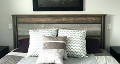 a bed with several pillows on it and a painting above the headboard in a bedroom