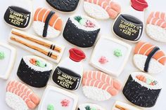 decorated cookies with sushi and chopsticks are arranged on a white tablecloth